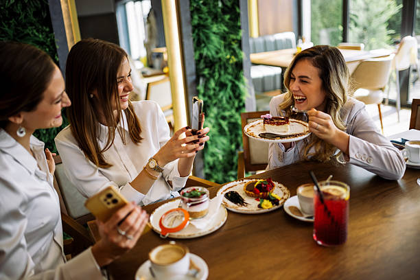 istock Three women enjoying cakes and taking photos in restaurant 2244191107