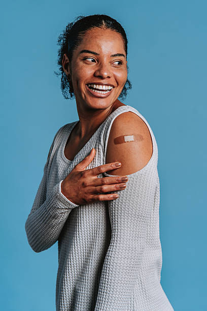 istock Smiling woman showing bandage after vaccination 2244191448
