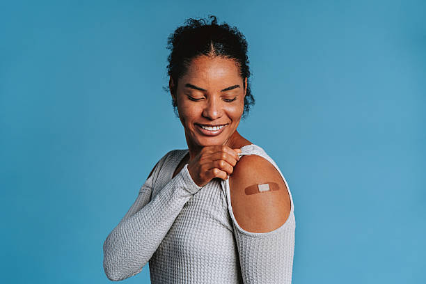 istock Smiling woman showing bandage after vaccination 2244191520