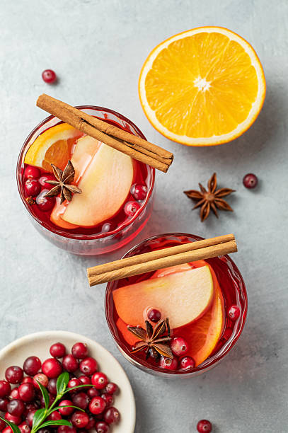 istock A cranberry drink in a two glasses on a light background with cinnamon, berries and citrus fruit. 2244194305