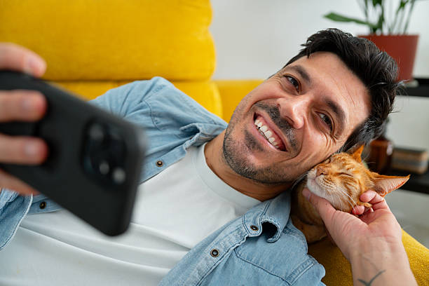istock Man and cat taking selfie with smart phone 2244197381