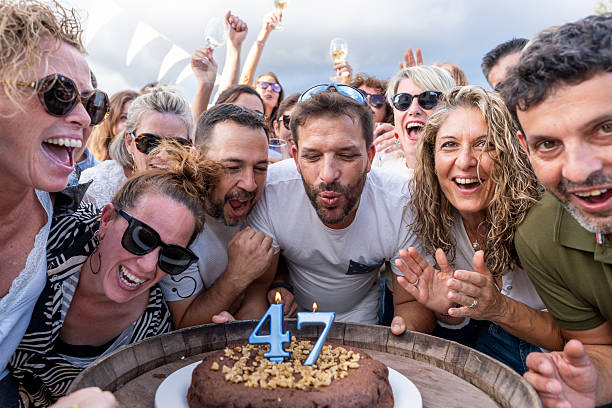 Group of adult friends cheering and smiling during a birthday celebration
