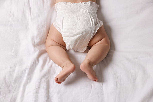 istock Cute little baby in diaper on bed, top view 2244198233