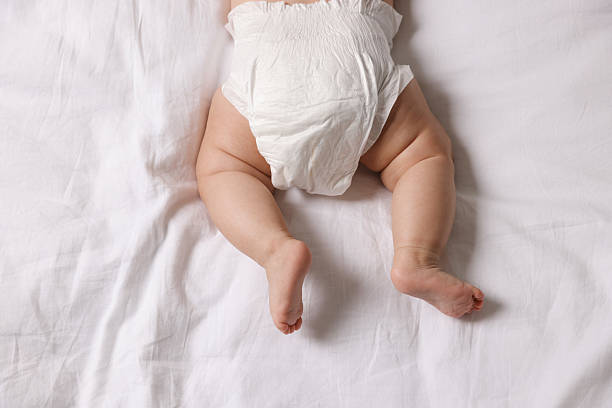 istock Cute little baby in diaper on bed, top view 2244198234