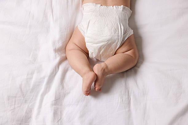 istock Cute little baby in diaper on bed, top view 2244198258