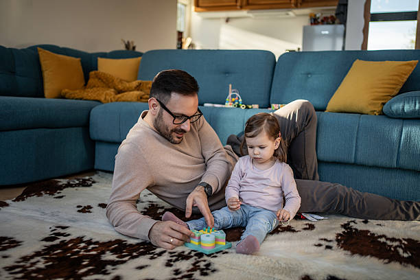 istock Father and young daughter playing toy on floor 2244200398