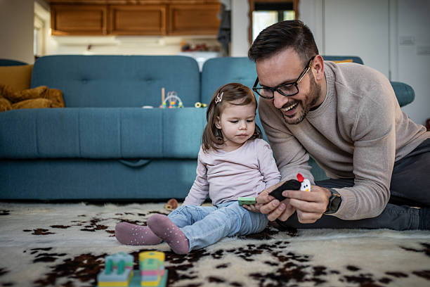 istock Father and daughter playing on carpet at home 2244201262