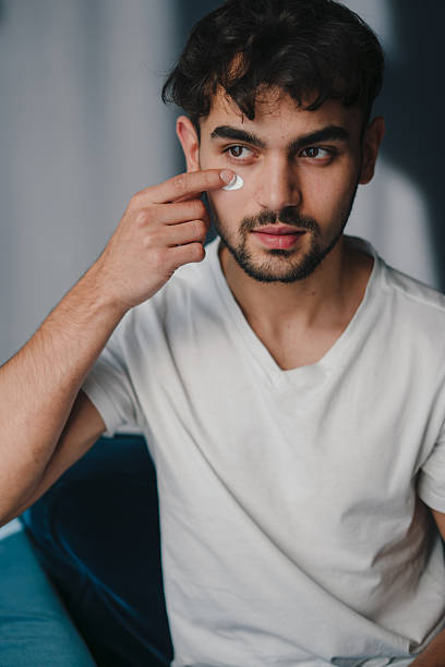 istock man checks eye, relaxed man with soft lighting and subtle beard examines his lower eyelid 2244202253