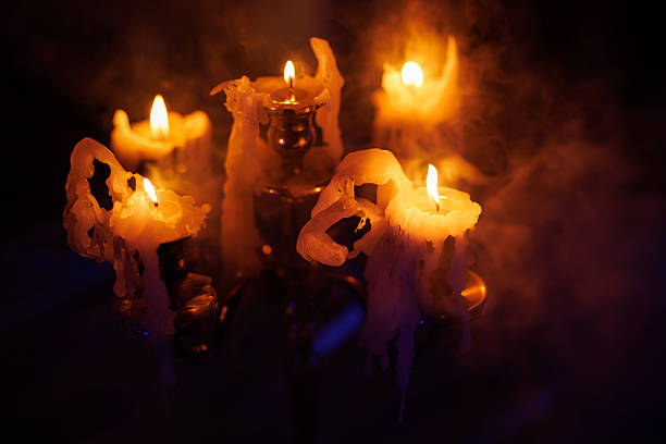 istock Candles burning with melted wax and smoke in dark atmosphere 2244204436
