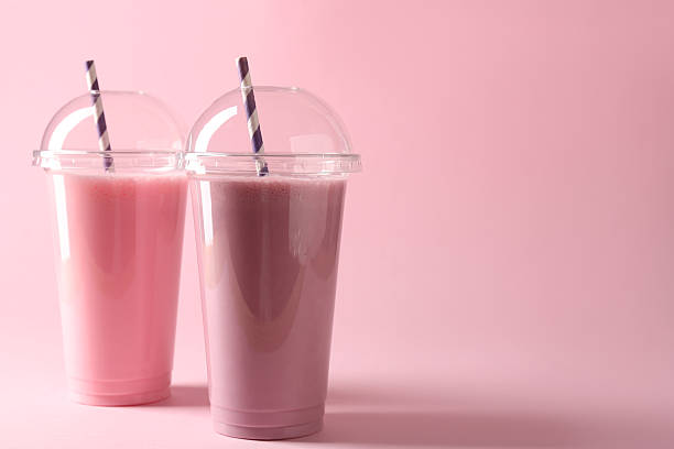 istock Tasty milkshakes in plastic cups on pink background, space for text 2244204889