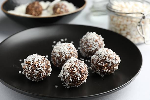 istock Tasty chocolate candies with coconut flakes on white table, closeup 2244205652