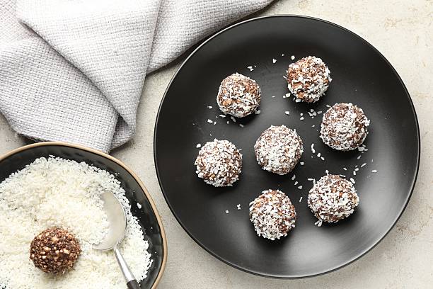 istock Tasty chocolate candies with coconut flakes on light table, flat lay 2244205666