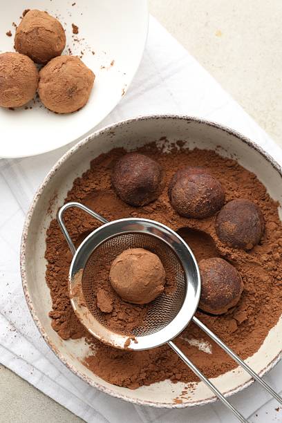 istock Making tasty chocolate candies with cocoa powder at light table, flat lay 2244206129