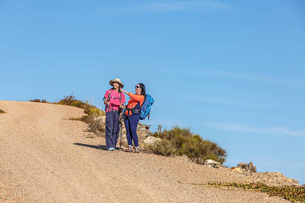 istock Two hikers enjoying a conversation on a sunny trail in a mountainous area 2244206355
