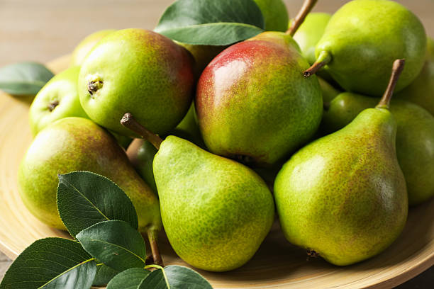 istock Fresh ripe pears and green leaves on table, closeup 2244208663