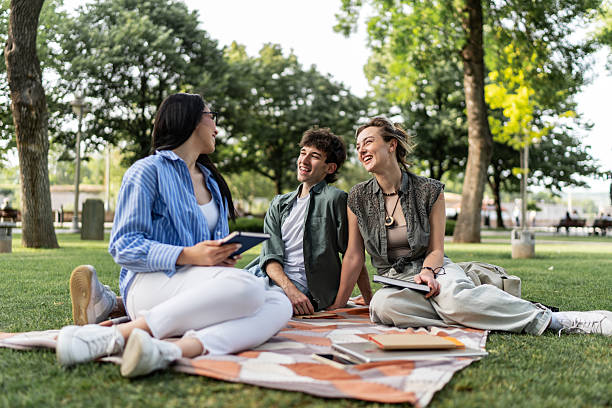istock Diverse young adults studying outdoors in summer park 2244209574