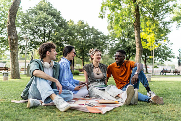 istock Diverse students relaxing in park talking and laughing 2244209689