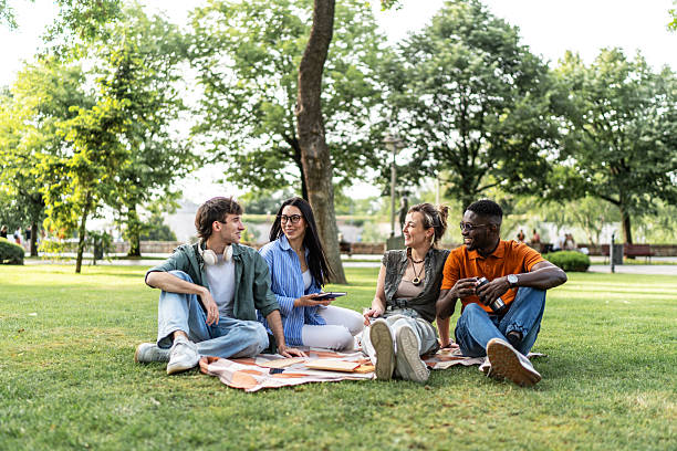 istock Young diverse friends relaxing and talking in park 2244209714
