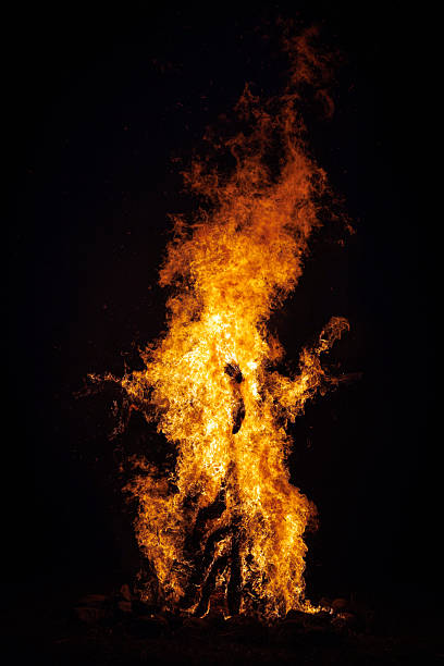 istock Tall bonfire flames against dark night sky 2244210295