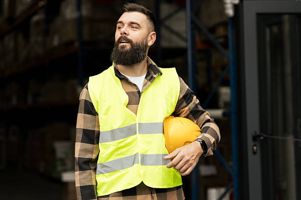 istock Smiling electrician holding helmet on work site 2244210827