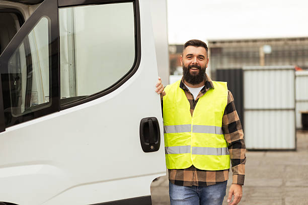 istock Young warehouse worker smiling beside delivery truck 2244211868