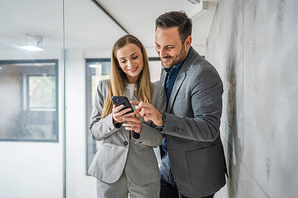istock Business colleagues looking at smart phone sharing information in office 2244212019