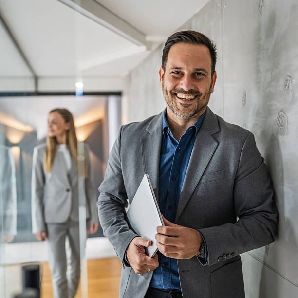 istock Business team standing in modern office corridor smiling 2244212224