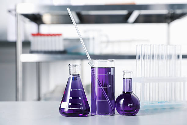 istock Different laboratory glassware with purple liquid on light table indoors 2244212458