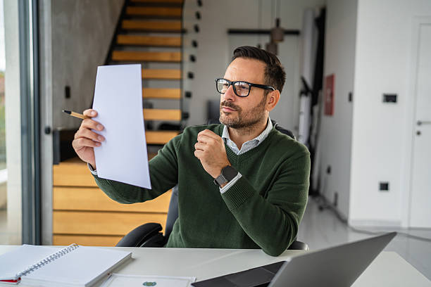 istock Businessman remotely working from home office reviewing document 2244213418