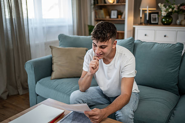 istock Teenager looking at homework results on couch 2244215311