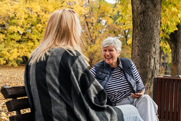 istock Mother and daughter talking in autumn park bench 2244216512