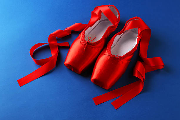 Pair of beautiful red pointe shoes on blue background