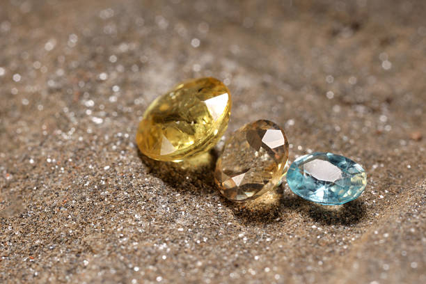 istock Beautiful shiny gemstones on sand, closeup view 2244218754