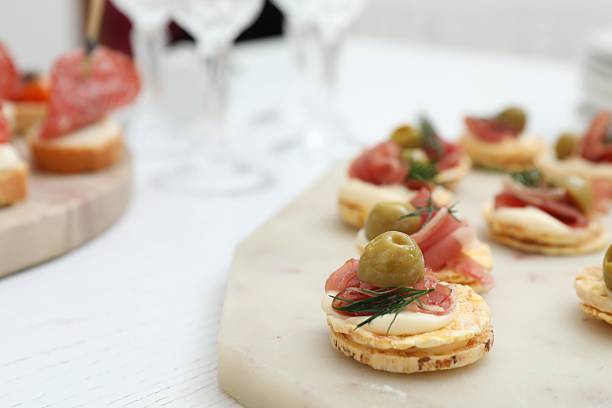 istock Many different tasty canapes on white wooden table, closeup 2244218939