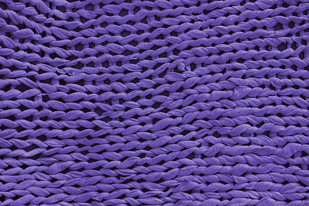 Macro, close up, detailed purple knitted textile, fabric texture with chunky yarn pattern suface. Cozy handmade cloth background, knitwear backdrop , perfect for design, crafts, warm winter concept