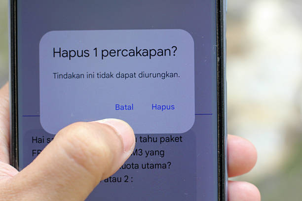 istock Deleting a chat on a smartphone with a finger hovering over the cancel button, decision making about data and communication on social media 2244221996