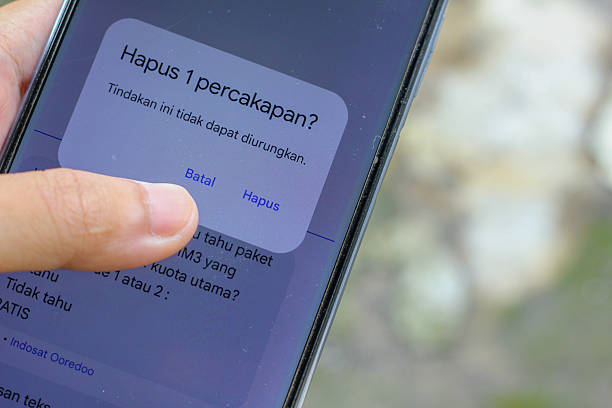 istock Deleting a chat on a smartphone with a finger hovering over the cancel button, decision making about data and communication on social media 2244222002