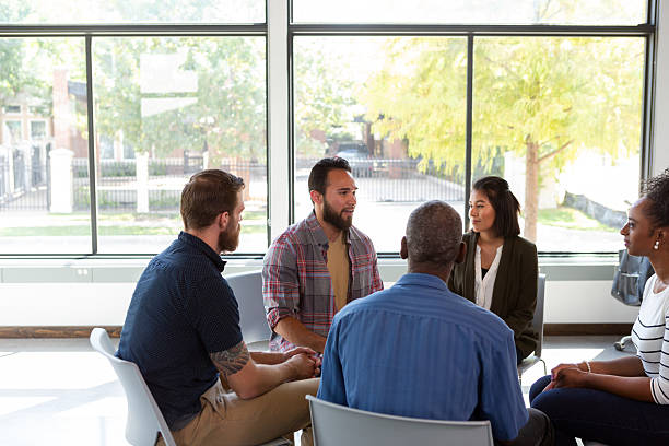 istock Diverse group of adults gathered for a supportive discussion in a bright, modern room 2244222487