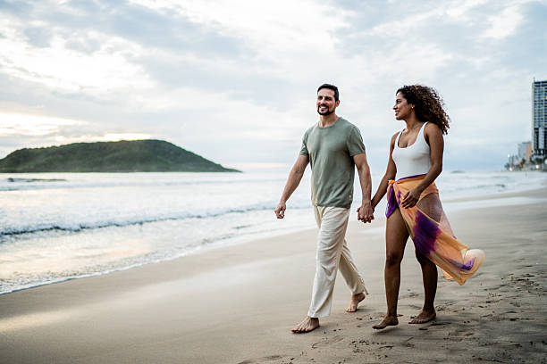 istock Couple talking and walking on the beach 2244222666