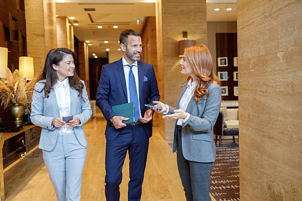 istock Business people having a conversation while walking in modern hotel corridor during a corporate event 2244229388