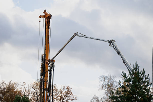 istock Tall drilling rig and concrete pump working together on construction site with cloudy sky representing building foundation process, infrastructure development and engineering work 2244229823