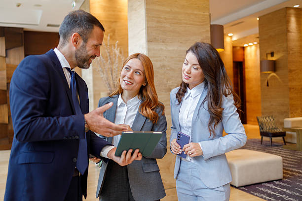 istock Business people having corporate discussion in hotel lobby, using digital tablet for project collaboration 2244230027