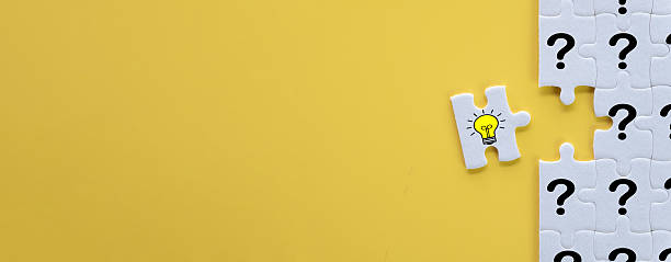 istock Finding the Solution: Lightbulb Idea Puzzle Piece Connecting Questions with copyspace or freespace. 2244230306