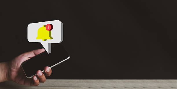 Hand holding smartphone with 1 new Message bell and speech bubble icon on black background concept for Online communication,Text massage,notification,reminder,email.