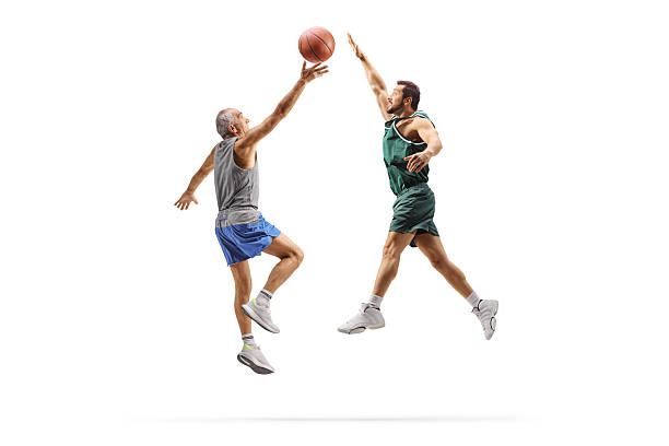 Senior man playing basketball with a younger athlete isolated on white background
