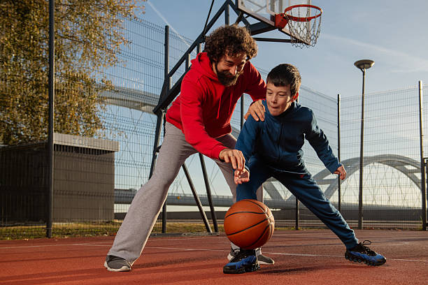 istock Father and Son Practicing Basketball Drills Together Outdoors 2244230644