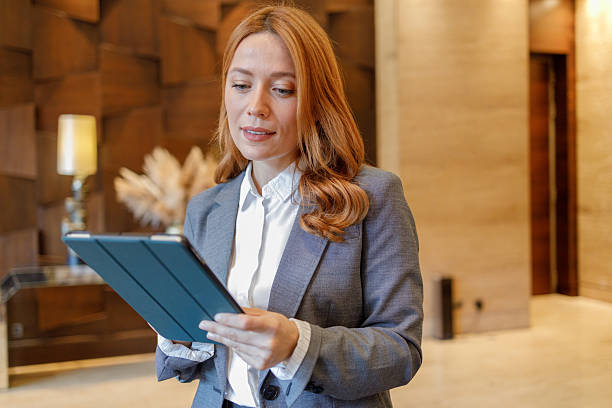 istock Professional businesswoman using a digital tablet for work, managing tasks in a corporate or hotel lounge 2244231248