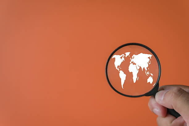 istock Focus on Global Business: Hand Holding Magnifying Glass over World Map Icon.,copyspace for put text or logo. 2244233520