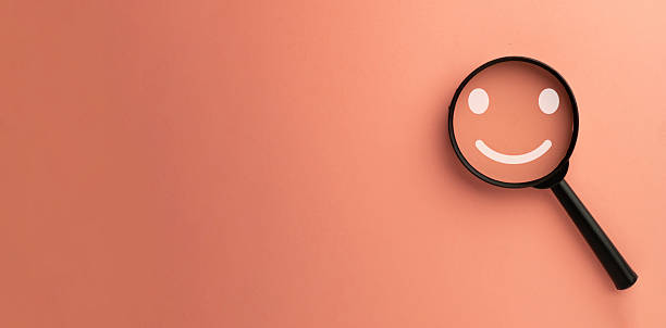 istock Focus on Customer Satisfaction: Magnifying Glass over Happy Smile Icon for Positive Feedback.,copyspace. 2244233548