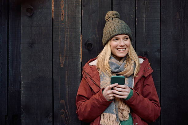 istock Happy woman using smart phone in autumn and looking way. 2244235128